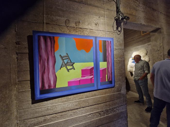 Kleurrijk schilderij met een klapstoel en roze kisten