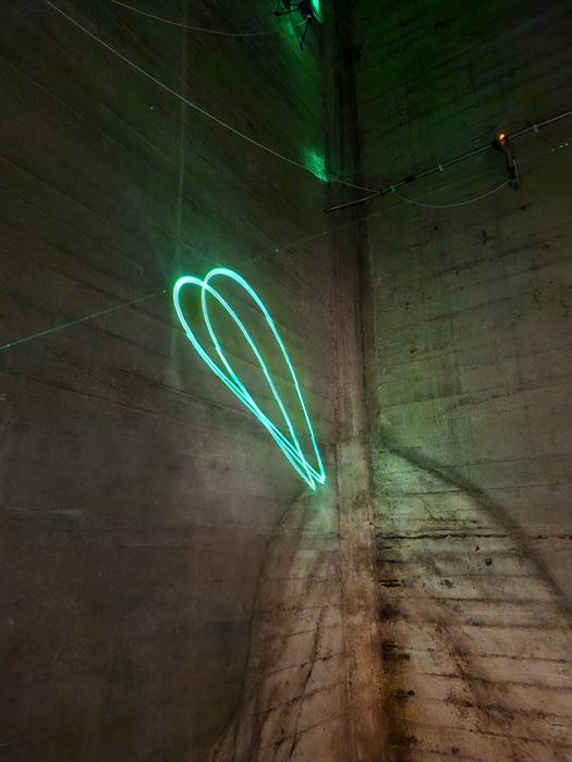 Groene lichtinstallatie in een betonnen ruimte