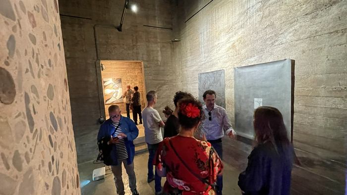 Bezoekers bij de expositie in de betonnen ruimte