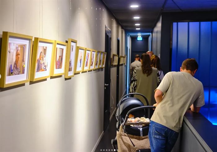 Bezoekers in de gang met ingelijste foto's